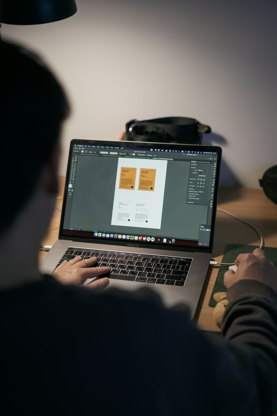 Designer working on Adobe Illustrator on a MacBook Pro.